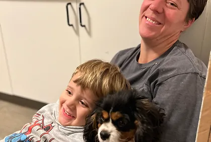 Child sharing a calm cuddle with a Cavalier King Charles Spaniel
